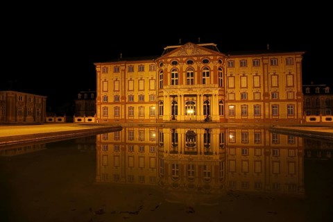 Baroque castle at night with lighting and reflection in the water basin, night view, Baroque
