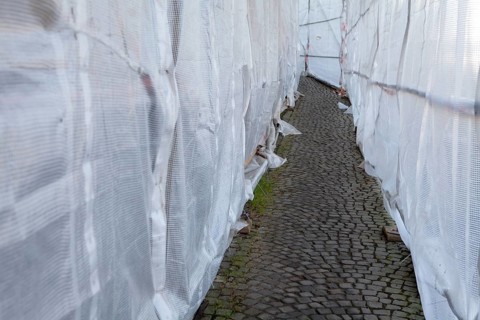 Footpath through a scaffolding with tarpaulin, Fußweg durch ein Baugerüst mit Abdeckplane