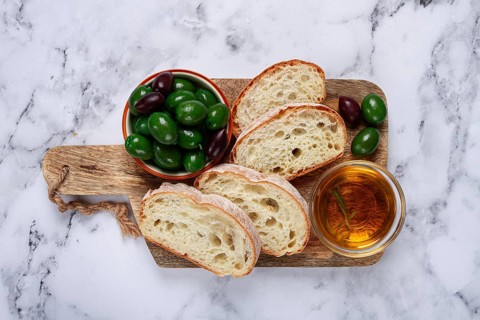 Appetizer, sliced ciabatta bread, with olive oil, green olives, Chalkidiki olives, classic Green