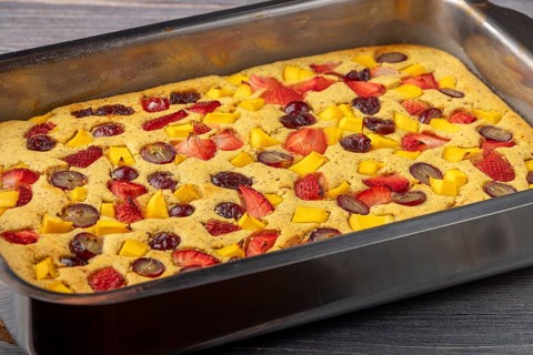 Freshly baked fruit cake in the shape of mango, strawberries and grapes