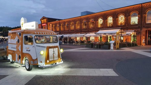 Illuminated food truck on a historic square in the evening atmosphere, Manufaktura, Lódz, Lodz,