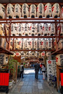 Japanese lanterns hang in a passage between houses, paper lamps with Japanese characters, Kyoto,