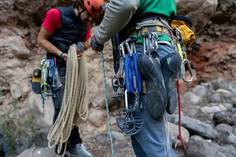 Climbers equipped with gear prepare for a traditional climbing adventure in natural surroundings.