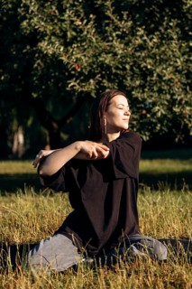 A teenage girl enjoys a peaceful morning in a lush garden, feeling the warm sun on her face. She