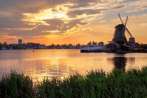 Windmills at famous tourist site Zaanse Schans in Holland on sunset with dramatic sky. Zaandam,
