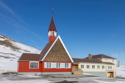 1958 red wooden Evangelical Lutheran Svalbard Church in the town Longyearbyen in winter,