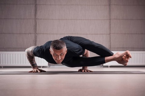 Adult man performs asana exercises. Yoga concept. Sports and healthy lifestyle.