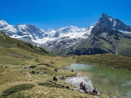 HIkers take a break at lake Lac d'Arpitetta, Zinal valley, Val d'Anniviers, Switzerland