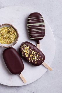 Top view of gourmet chocolate covered ice creams garnished with matcha blend, presented elegantly