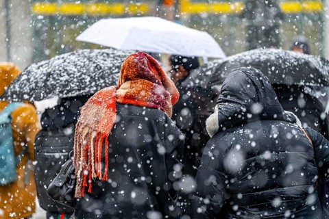 Winter weather, heavy snowfall, city centre traffic, passers-by in the snow, person with thick