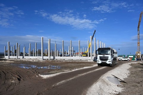 Construction of a large factory building with prefabricated elements in a vegetable growing area,