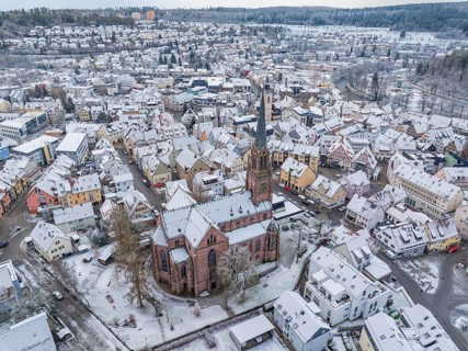 Townscape in winter with snow-covered roofs and a central church, Nagold, Black Forest, Germany