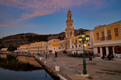 Coastal town view at dusk, illuminated buildings and harbour promenade, Holy Week, Bay of