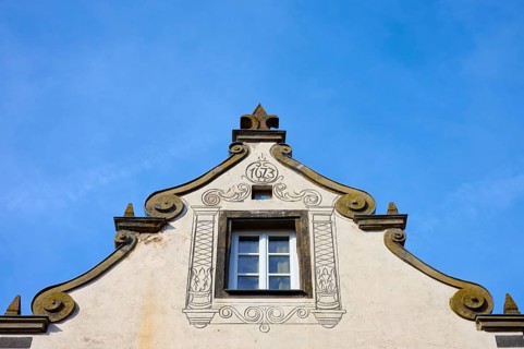 A baroque decorated roof with a central window against a clear blue sky, Wolframs-Eschenbach,