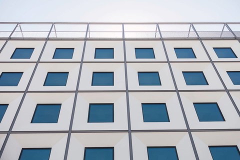 A contemporary building facade with a geometric pattern of windows creates a striking visual effect