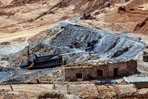 Quarry operation in a barren area with trucks and workers, The Potosi silver mines on Cerro Rico in