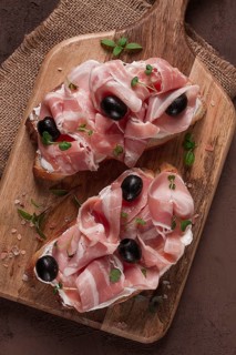 Breakfast, bacon and olives sandwich, on a cutting board, top view, close-up, no people