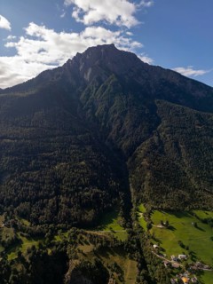 A breathtaking aerial view of the lush, green landscape and towering mountains near Brig,