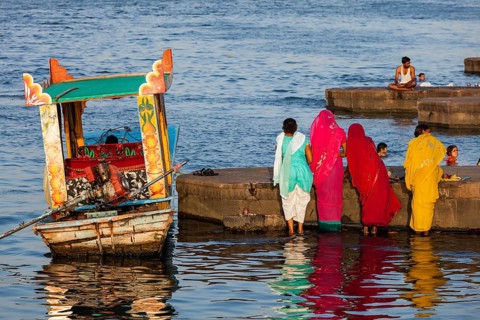 MAHESHWAR, INDIA, APRIL 26, 2011: Indian women doing morning pooja on ghats of sacred Narmada river