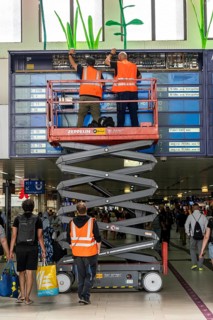 Technicians working on an electronic information board, display board for train connections at