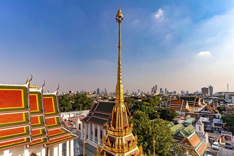 The Buddhist temple complex Wat Ratchanatdaram and the skyline of Bangkok, Thailand