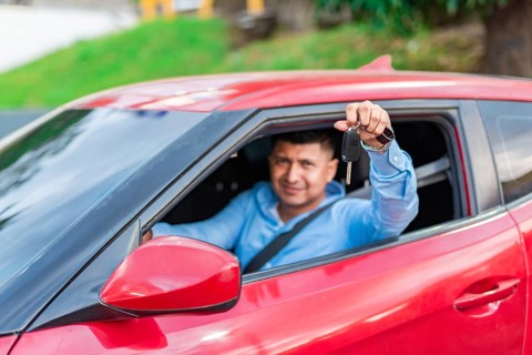 Male driver showing his car keys. Happy driver showing car key
