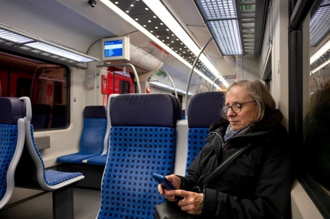 Elderly woman sitting in suburban train, train, operating mobile phone, smartphone, Stuttgart,