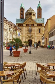 Street scene with café tables in the foreground, Speyer Cathedral and cloudy sky, Speyer