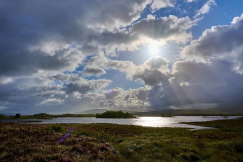 Reflecting lake under a sky with dramatic clouds and sun rays, Rannoch Moor, Bridge of Orchy,