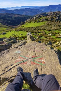 Feet of a man sitting on the top of Mount Adarra in Urnieta. Gipuzkoa, Basque Country