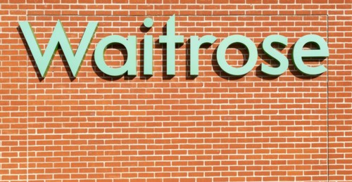 Waitrose shop sign on brick wall, UK