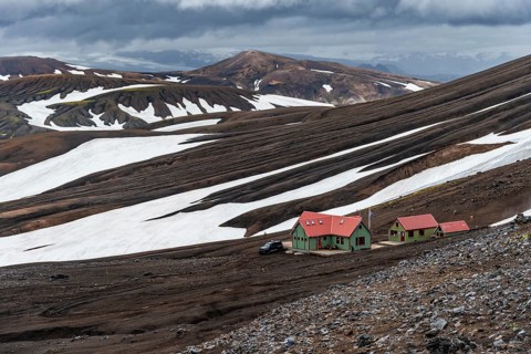 Dramatic volcanic landscape with mountains and snow, Höskuldsskáli hut in Hrafntinnusker,