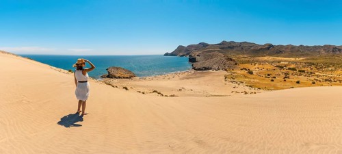 Panoramic photo of a woman on a hill with sea views in Cabo de Gata, Spain
