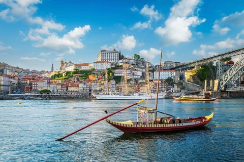 View of Porto city and Douro river with traditional boats with port wine barrels and sailing ship