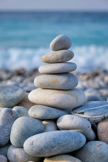 Zen meditation relaxation concept background, balanced stones stack close up on sea beach