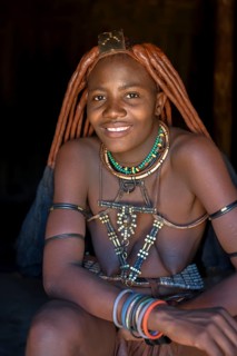 Young Himba woman in her hut, Ohandungu, Kunene region, Kaokoveld, Namibia