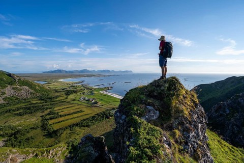 Climber on a rock, view of coastal landscape with the village of Stave, beach and sea, hike to the