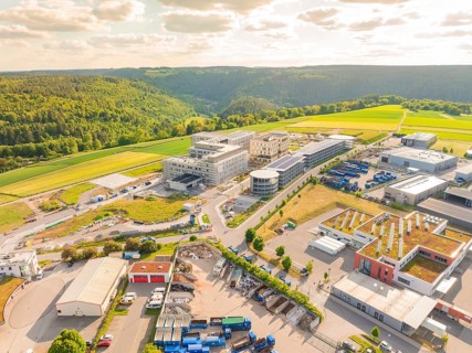 Industrial area with various buildings embedded in a hilly landscape, construction of the new