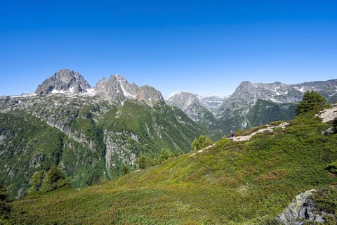 Mountaineer on hiking trail to Aiguillette des Posettes, mountain panorama with summit Aiguille de