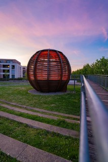 Spherical wooden building at sunset, modern style, sky in shades of red and purple with building in