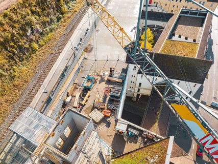 Top view of a crane construction site with equipment and buildings in an urban area, ZOB Calw