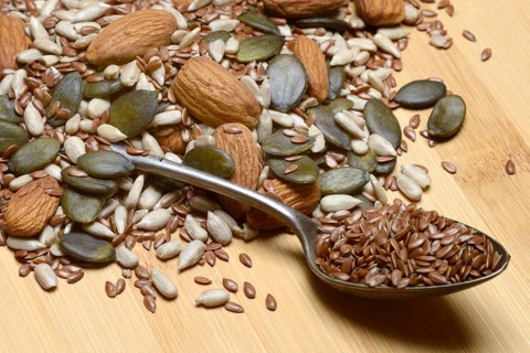 Seeds in spoons, mix of almond seeds, sunflower seeds, linseeds and pumpkin seeds