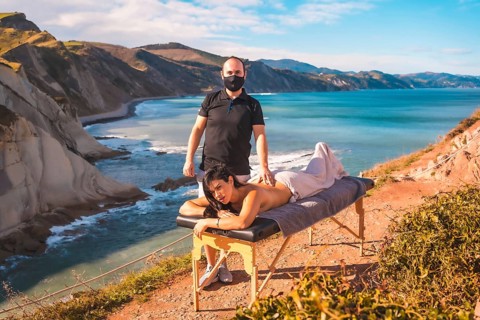 A young man performing a nature massage on the coast near the sea, a dream come true, masseur with