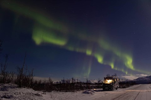 Motorhome under northern lights in winter, Finnmark, Norway