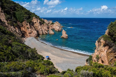 Red rocks and secluded beach, Spiaggia di Tinnari, Costa Paradiso, Sardinia, Italy