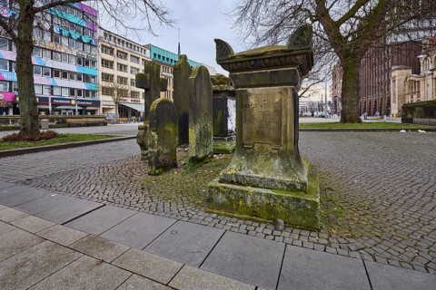 Historic gravestones, general architecture, pavement made of cobblestones and paving slabs, diffuse