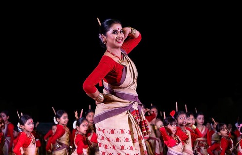 An instructor dance as participants follows the dance step in a Bihu dance workshop ahead of