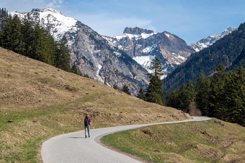 Female hiker on the Oytalstraße from Oberstdorf to Oytal with a view of Oytal behind Kratzer and