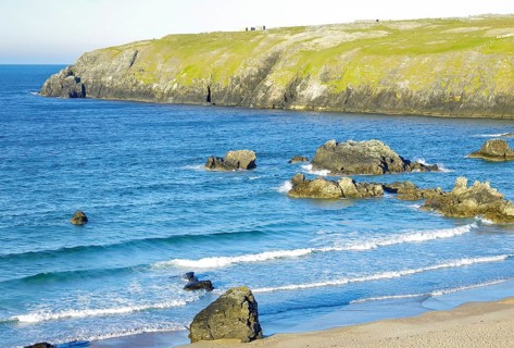 Picturesque coast with smooth-washed stones and deep blue sea under clear skies, Durness,