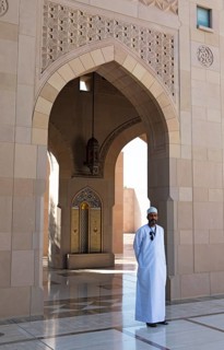 Omani man in dishdasha at an archway in the Sultan Qabus Grand Mosque, Muscat, Muscat Province,